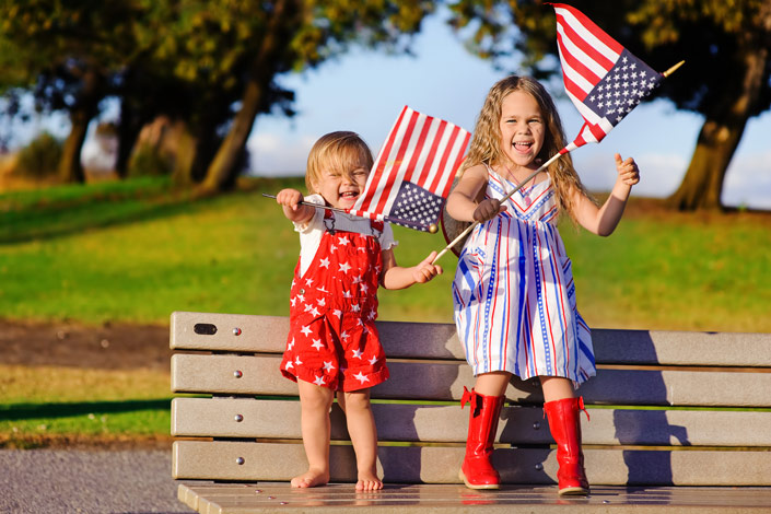 Happy little girls waving american flags